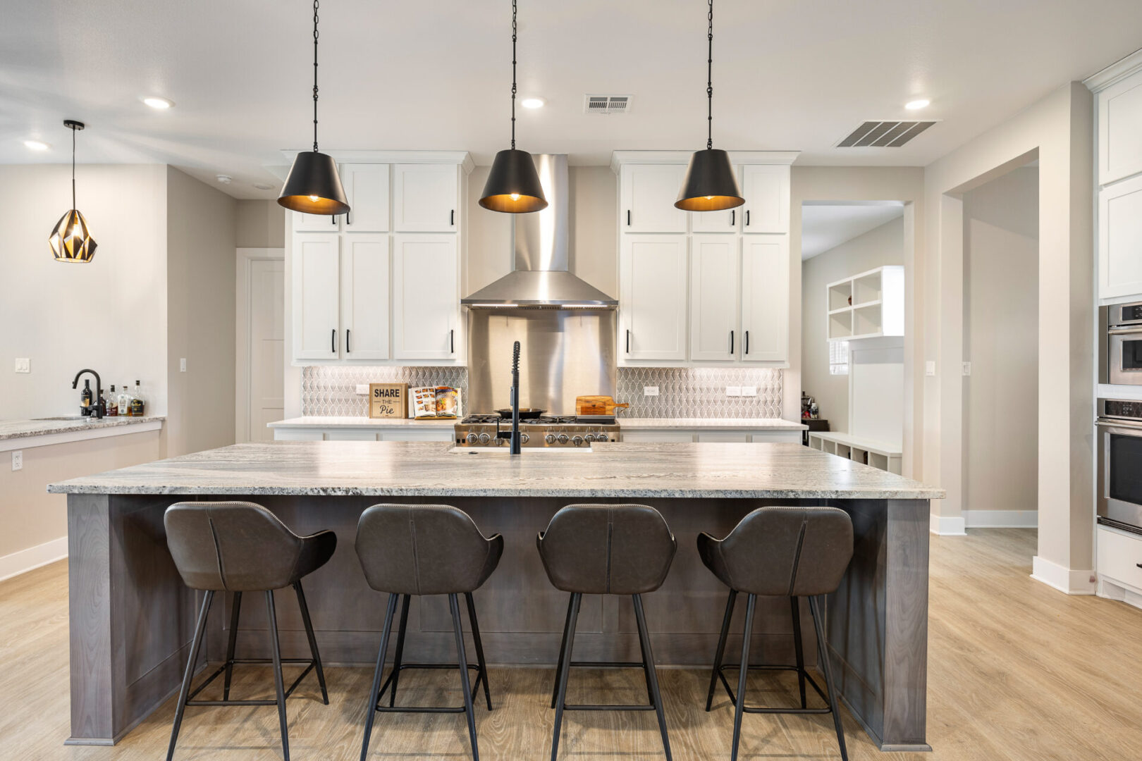 KCE Homes, spacious kitchen, double ovens, range, stainless steel vent hood, modern lights, white cabinets