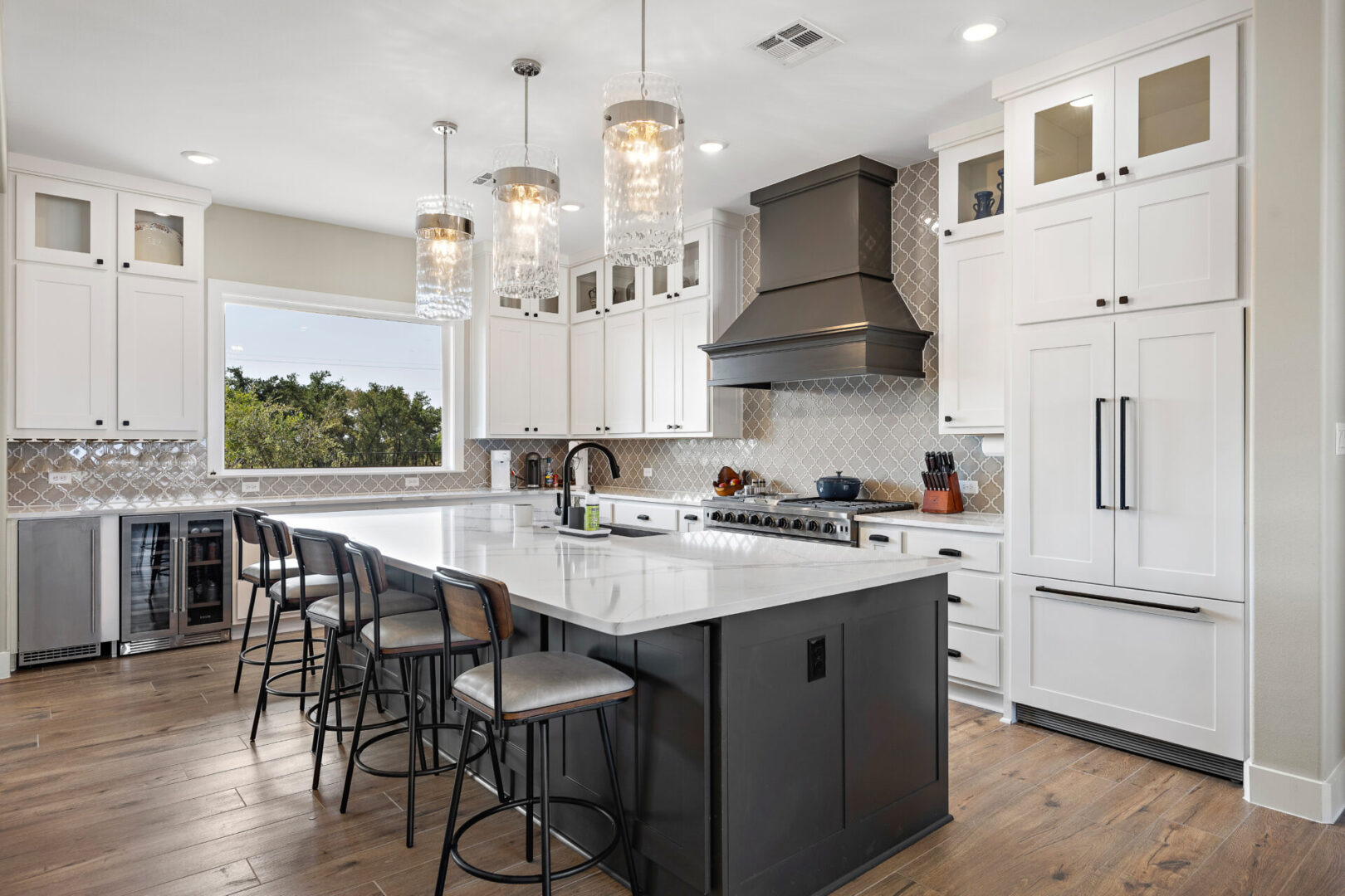 KCE Homes, country living, farmhouse kitchen, hidden refrigerator, vent hood, pendant lights, large kitchen island